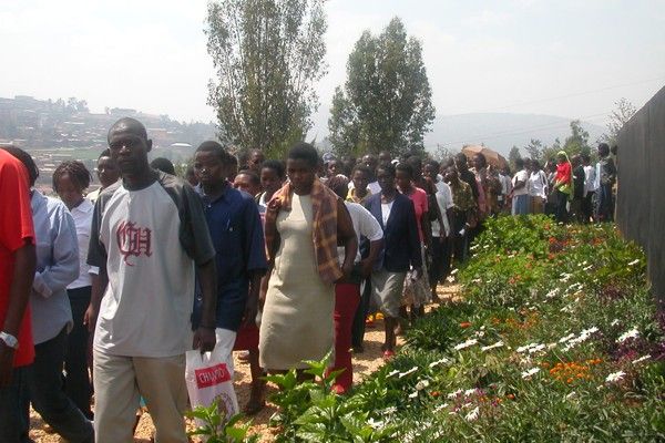 Ruanda: Eine Gruppe folgt einem Weg, der mit Blumen gesäumt ist