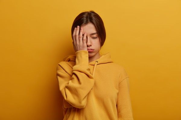 Frau hält Hand vor ihr Gesicht