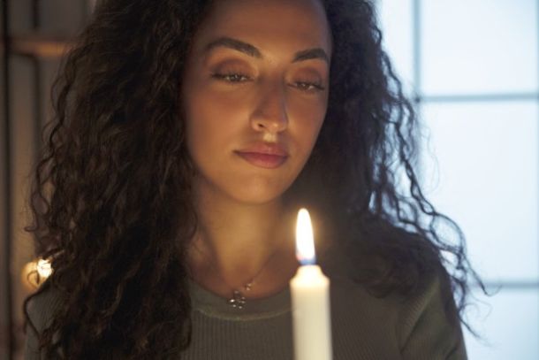 young woman holds candle