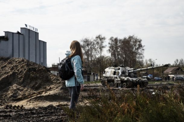 Girl looks at a destoyed Tank