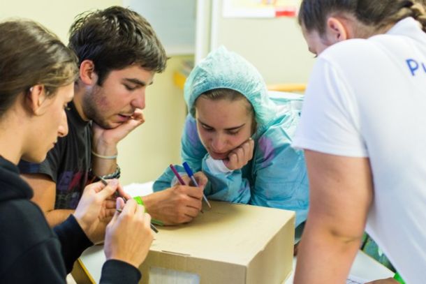 Teenagers writing on card board